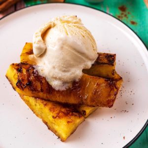 Honey Grilled Pineapple on a plate topped with vanilla ice cream