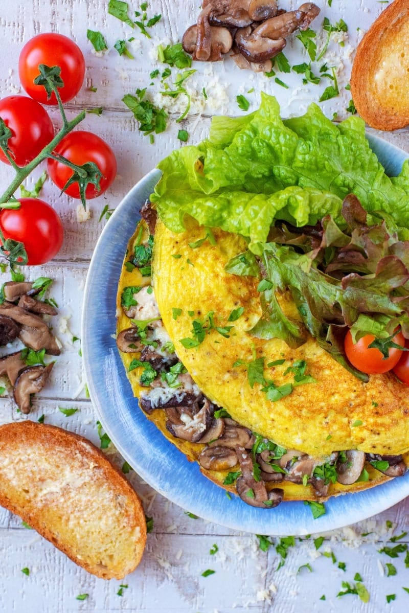 A mushroom omelette on a plate with salad.