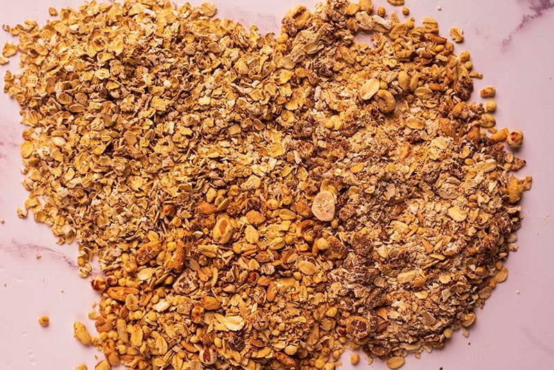 Oats and cereals all mixed together on a marble surface.
