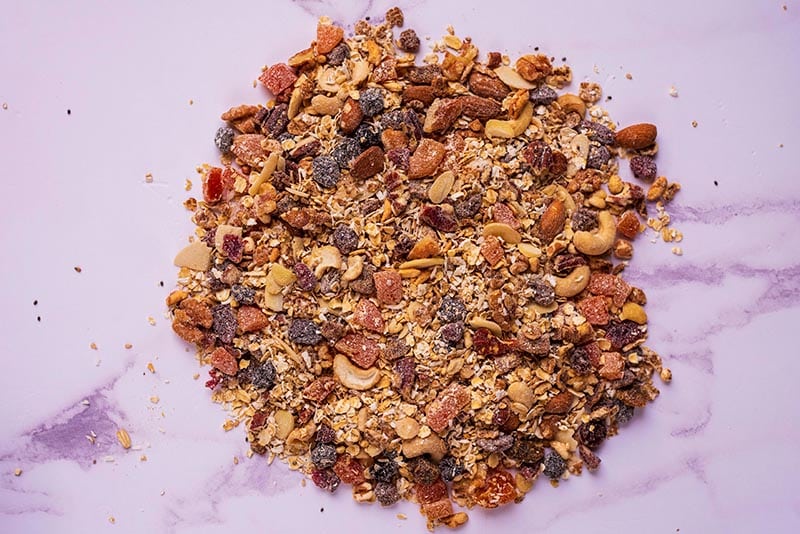 Homemade muesli all mixed together on a marble surface.