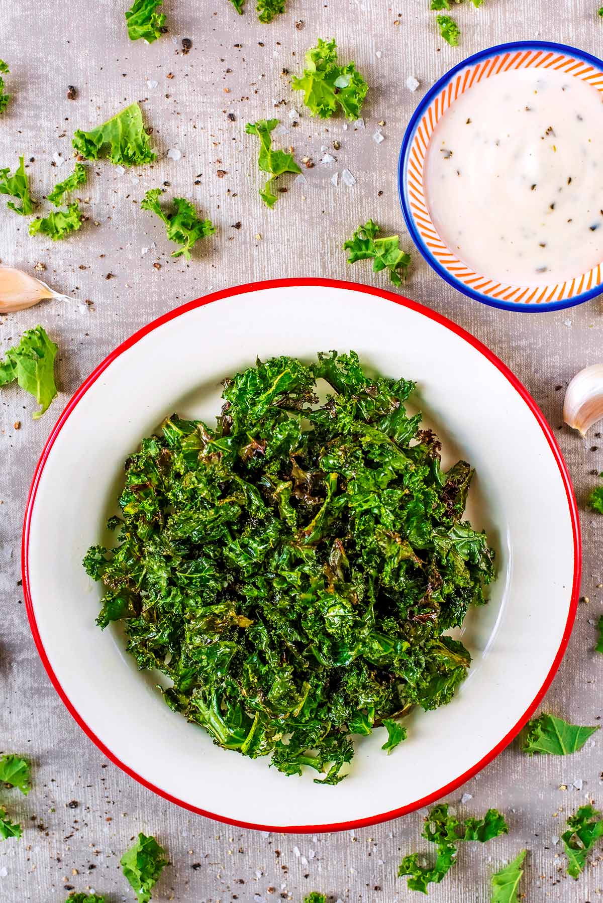 Kale Crisps on a plate next to a small dish of dip.