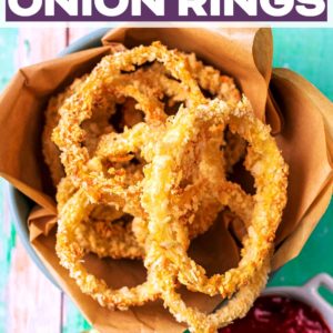 A bowl of oven baked onion rings with a text title overlay.