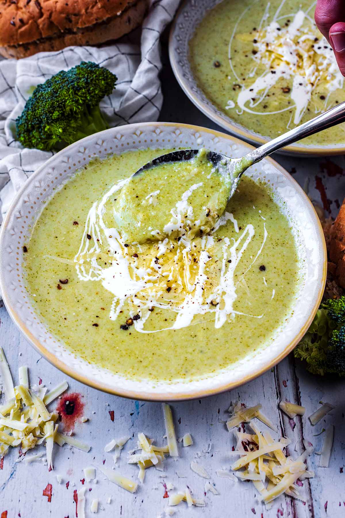 A spoon lifting some soup out of a bowl.