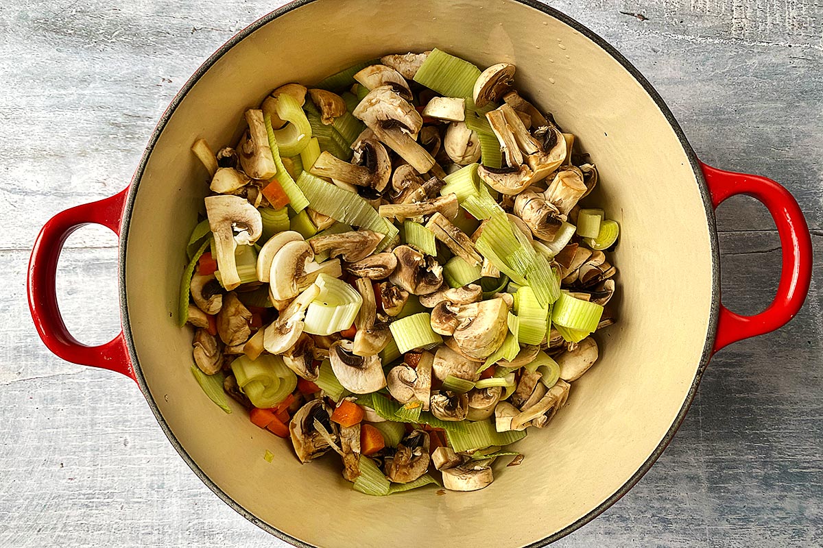 Mushrooms, leeks and carrots cooking in a large pot