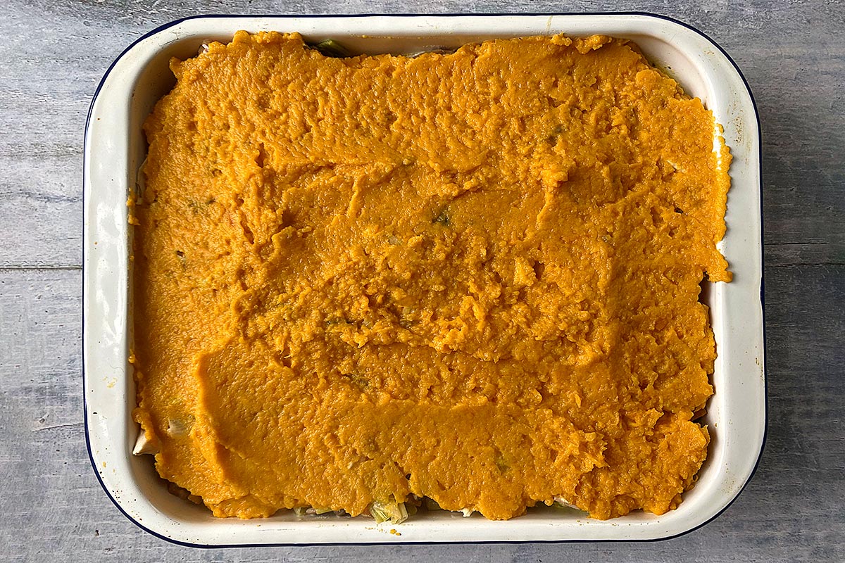 Mashed sweet potato topping on a pie in a baking dish