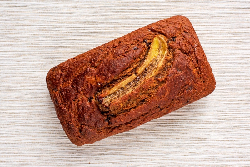 Cooked banana bread with a sliced banana on top.