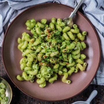 A bowl of creamy avocado pasta with a fork in it.