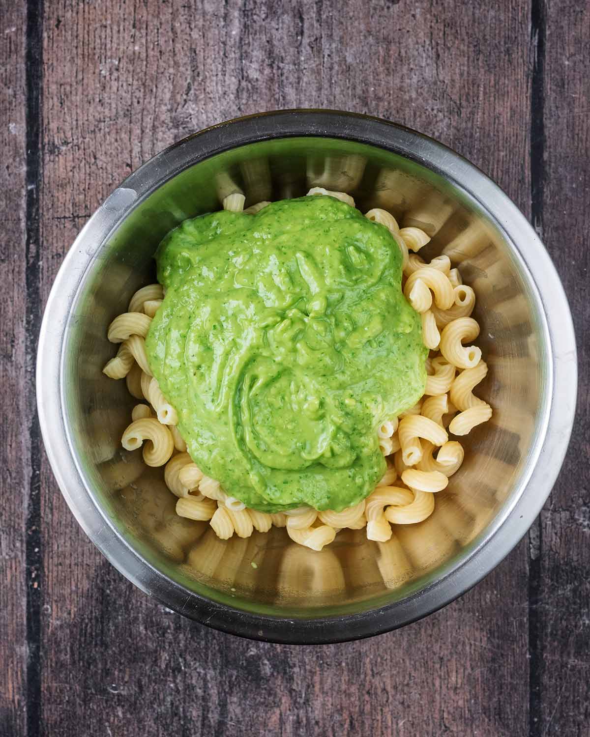 A bowl with cooked pasta and the avocado pasta sauce.
