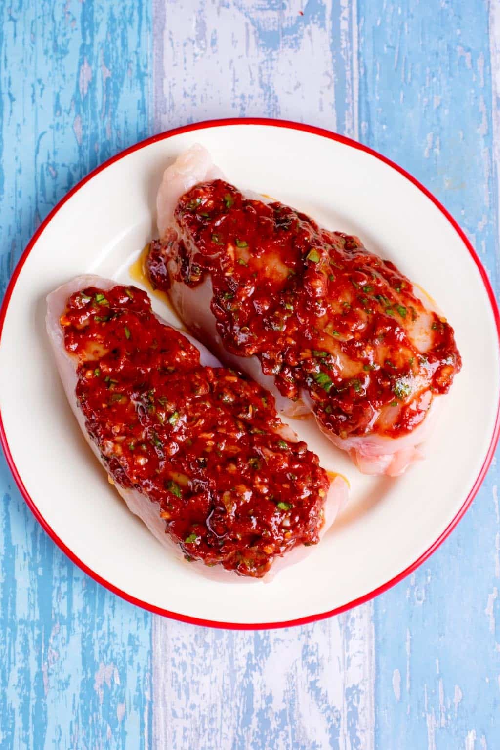 Chicken breasts covered in a tomato marinade.