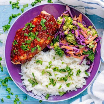 Marinated Chicken Breasts on a plate with rice and slaw.