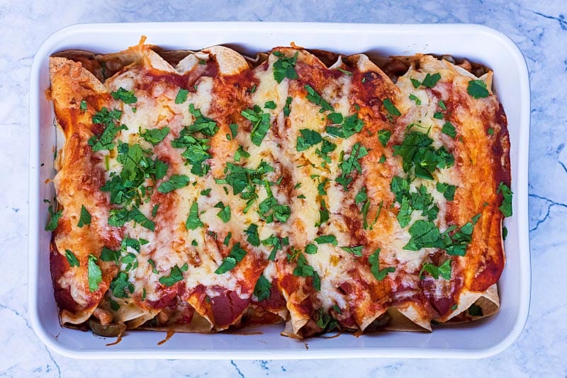 Baked enchiladas with chopped cilantro sprinkled on top.