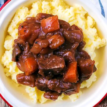 Slow Cooker Beef Casserole and mashed potato in a white dish.