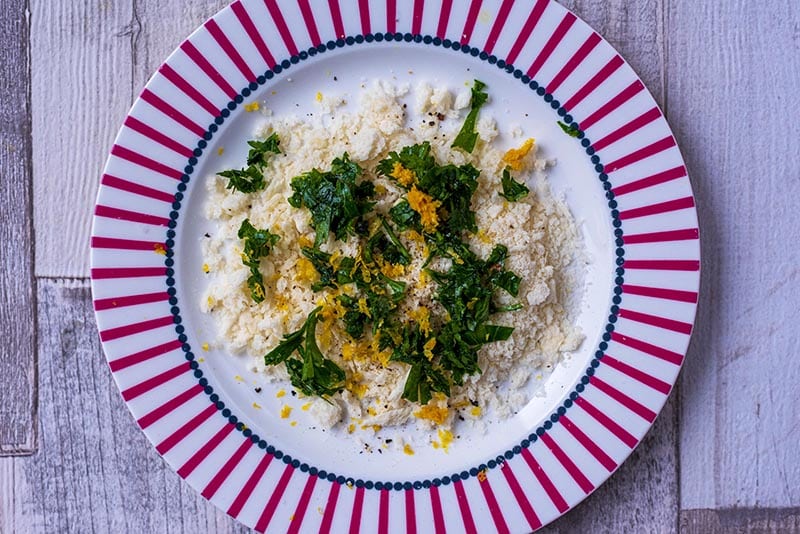 A plate with breadcrumbs, chopped herbs and lemon zest.