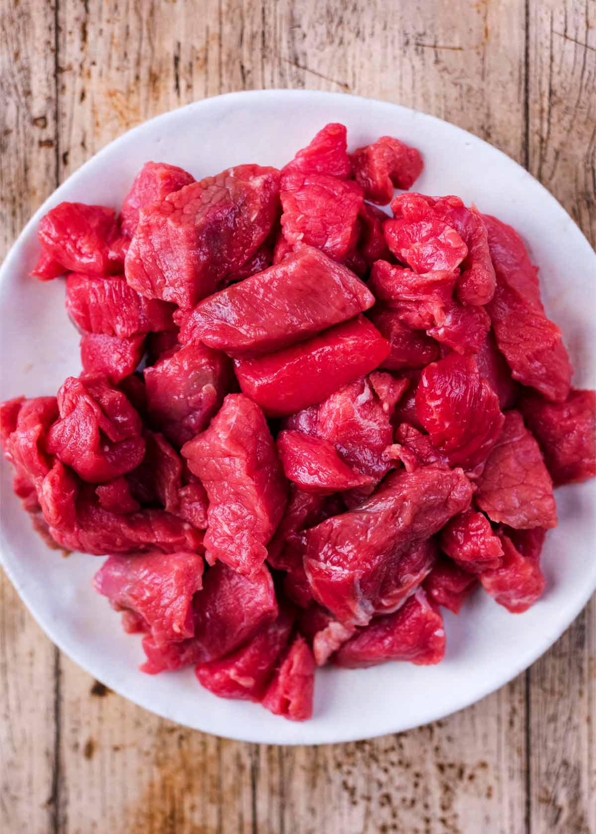 A plate of raw beef cubes.