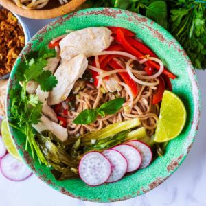 Pho Ga chicken noodle soup in a green bowl.