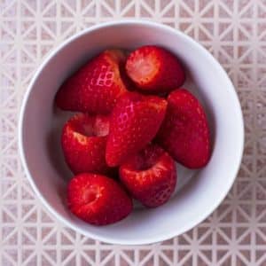 A small bowl of hulled strawberries