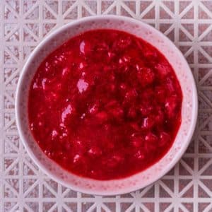 A small pink bowl full of strawberry puree