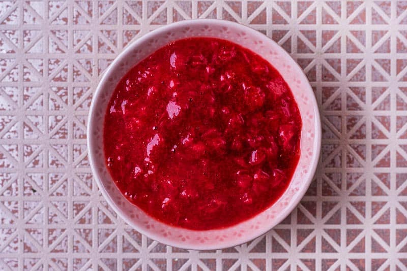 A small pink bowl full of strawberry puree.