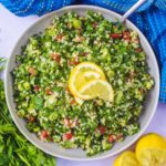 A bowl of tabbouleh topped with lemon slices.