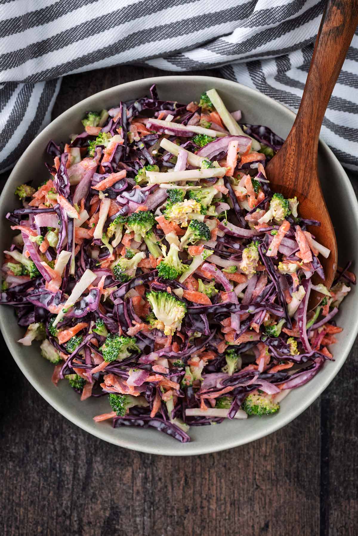 A large bowl of slaw containing broccoli, cabbage, onion and carrot.