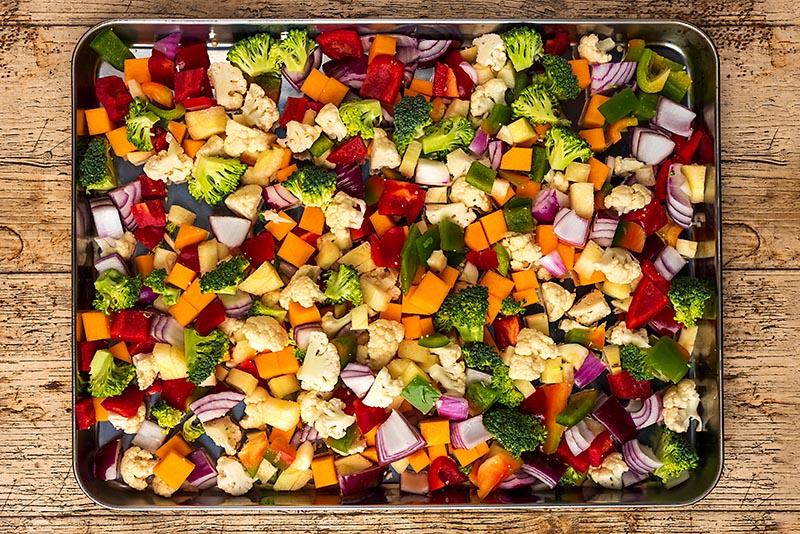 Chopped vegetables on a large baking sheet.