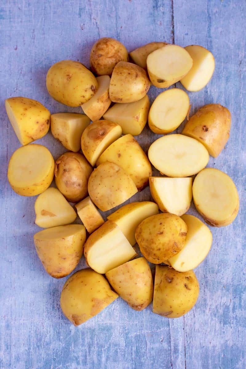 A pile of cut potatoes on a blue background.