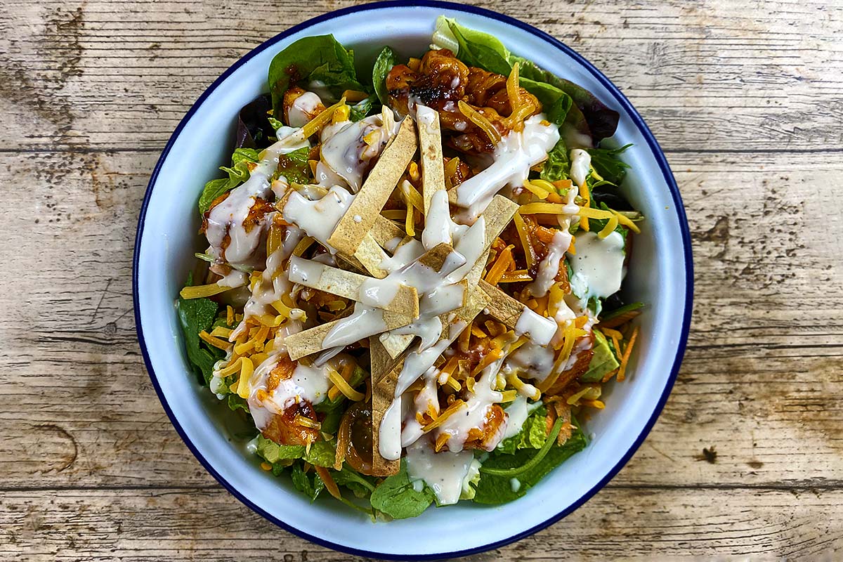 Barbecue chicken salad with ranch sauce drizzled over it.