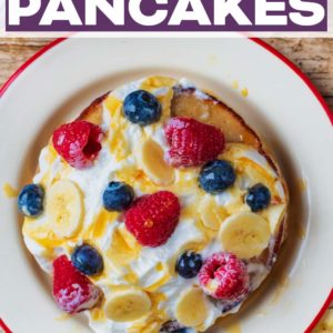 A plate of banana pancakes covered in cream and berries with a text title overlay.
