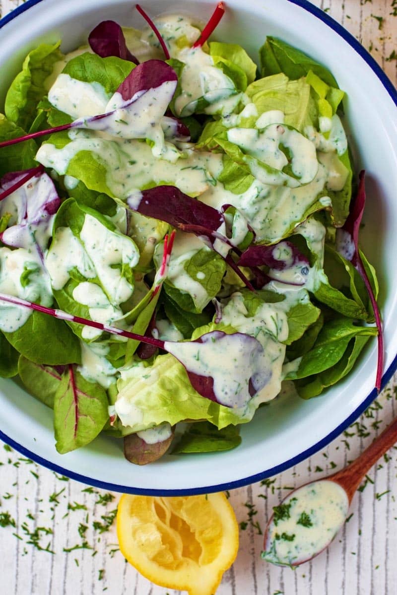 A bowl of salad leaves covered in a healthy ranch dressing.