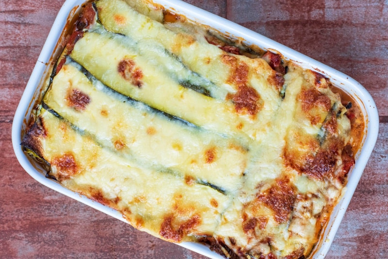 Low carb lasagna showing a zucchini and melted cheese topping.