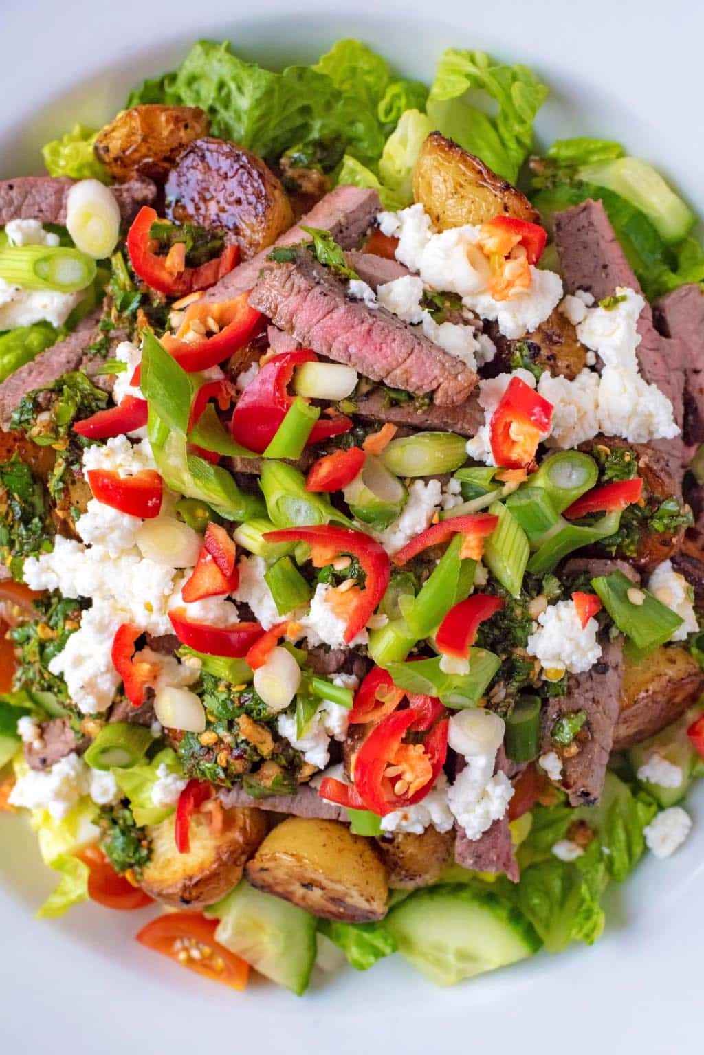 Salad leaves topped with sliced steak, cheese and chillies.