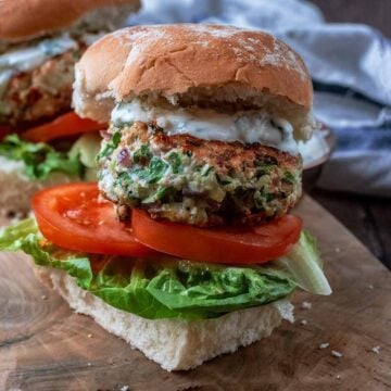 A Greek turkey burger on a wooden board.