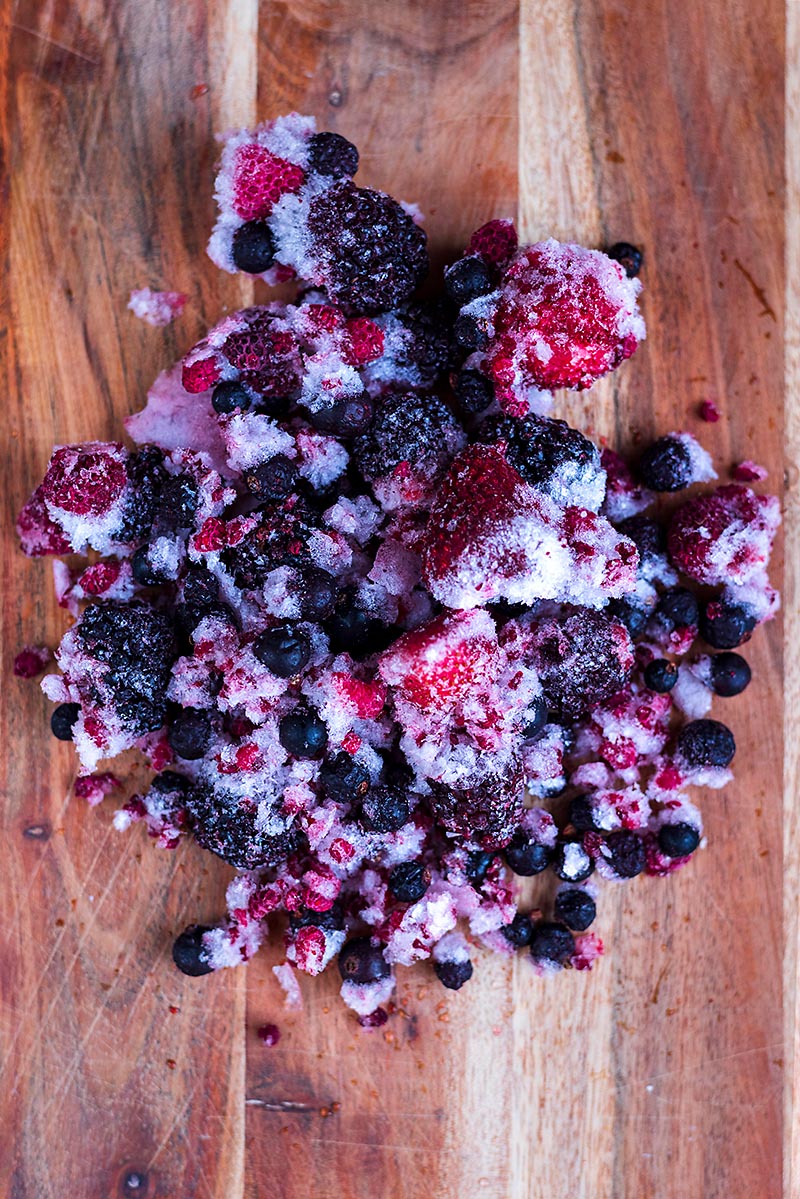 A pile of frozen berries on a wooden board.