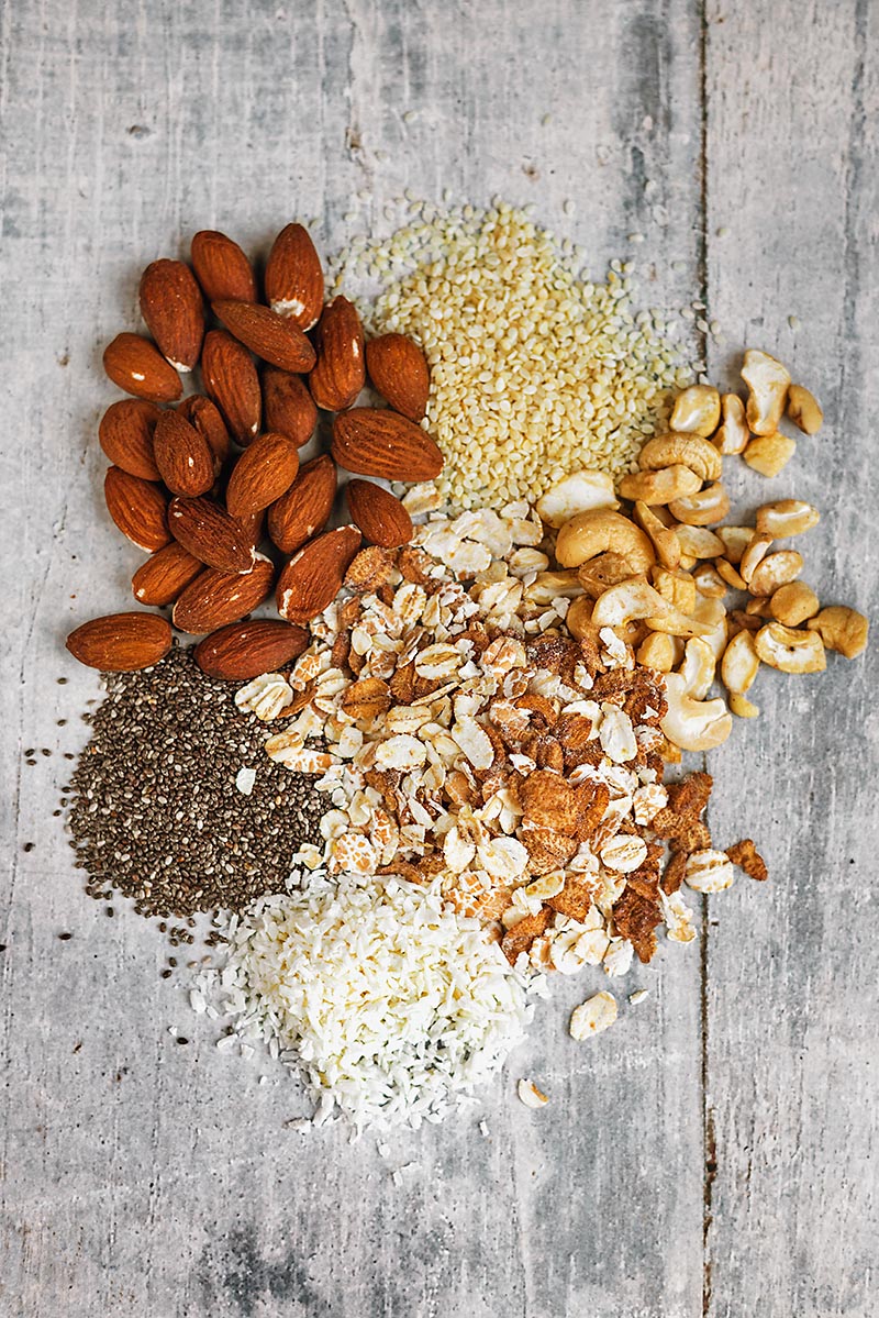 A selection of oats, nuts and seeds on a wooden surface