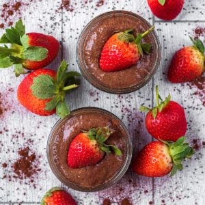 Two pot of Chocolate Chia Pudding topped with strawberries
