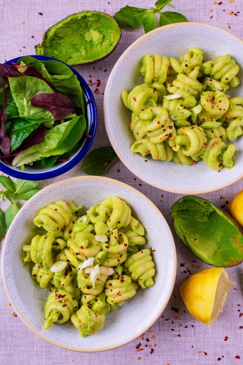 Two bowls of pasta in an avocado sauce.