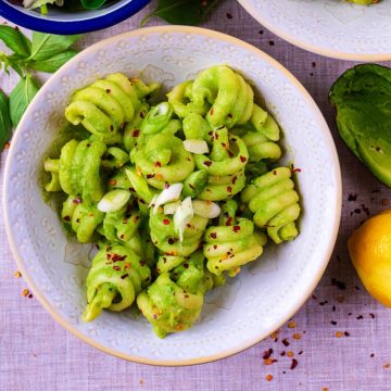A bowl of Creamy Avocado Pasta with chilli flakes sprinkled on top