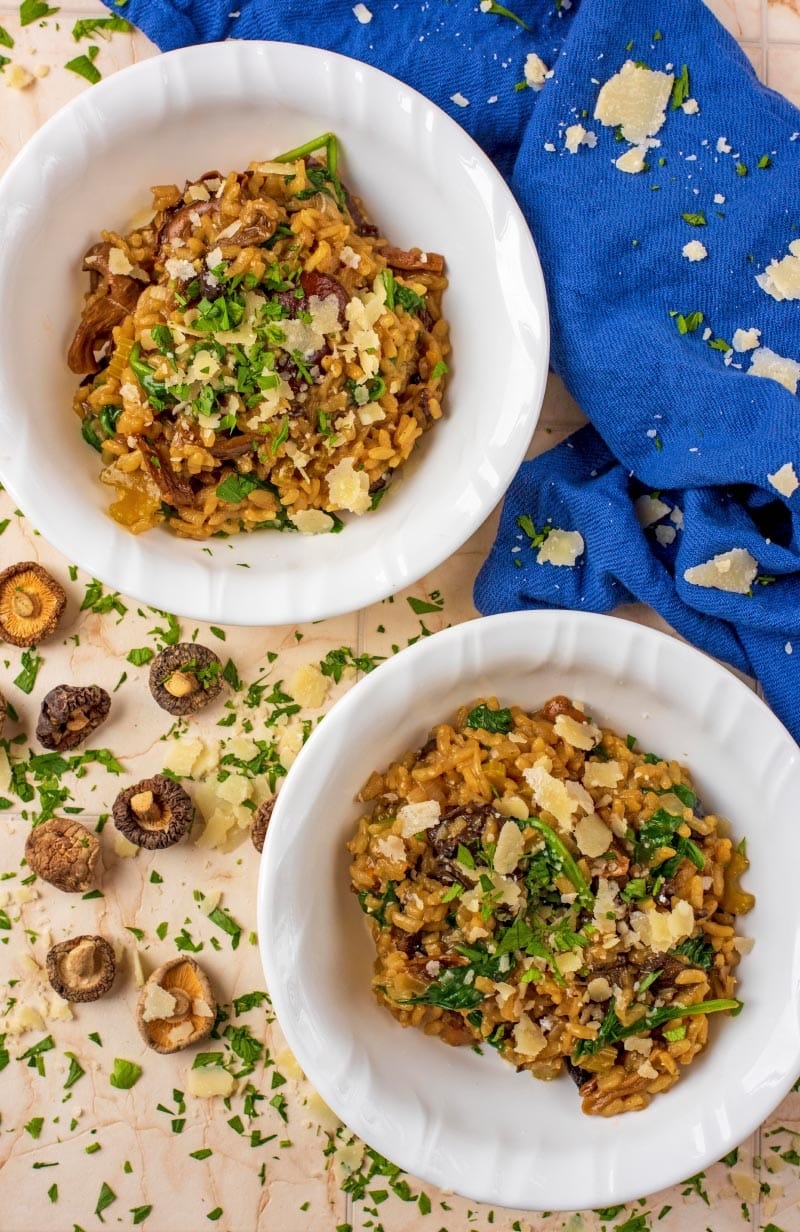 Two white bowl filled with risotto. A blue towel next to them.