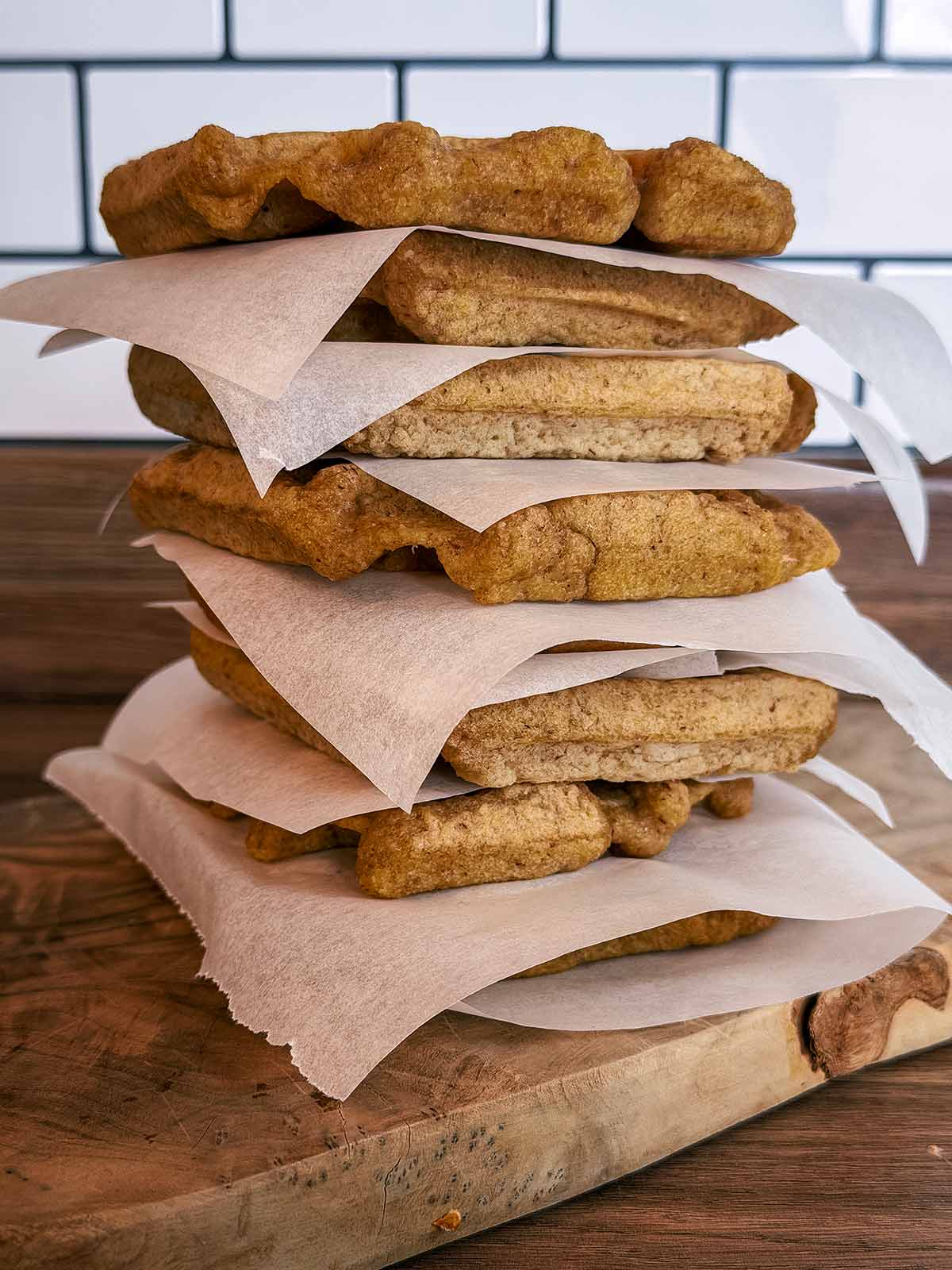A stack of waffles with baking paper between each one.
