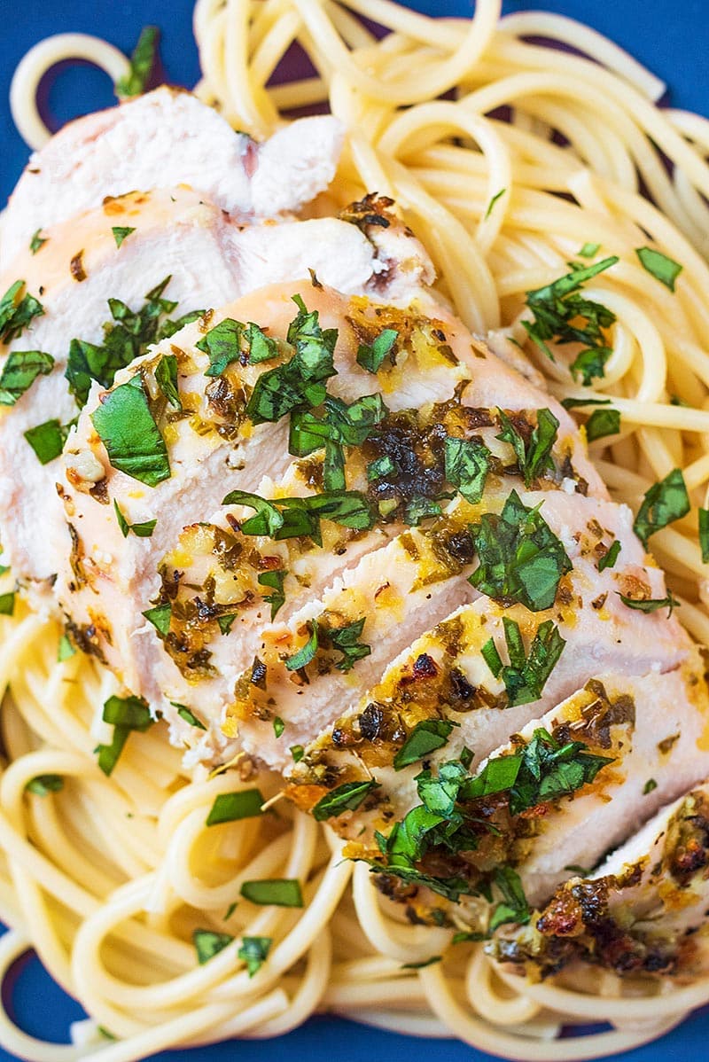 Sliced cooked chicken breast on top of spaghetti.