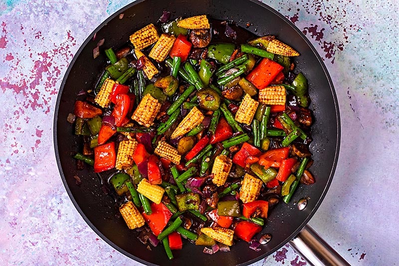 Chopped vegetables cooking in a teriyaki sauce.
