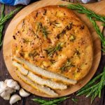 Garlic and rosemary focaccia with three slices cut off.