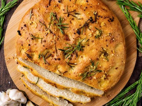 Garlic and rosemary focaccia with three slices cut off.