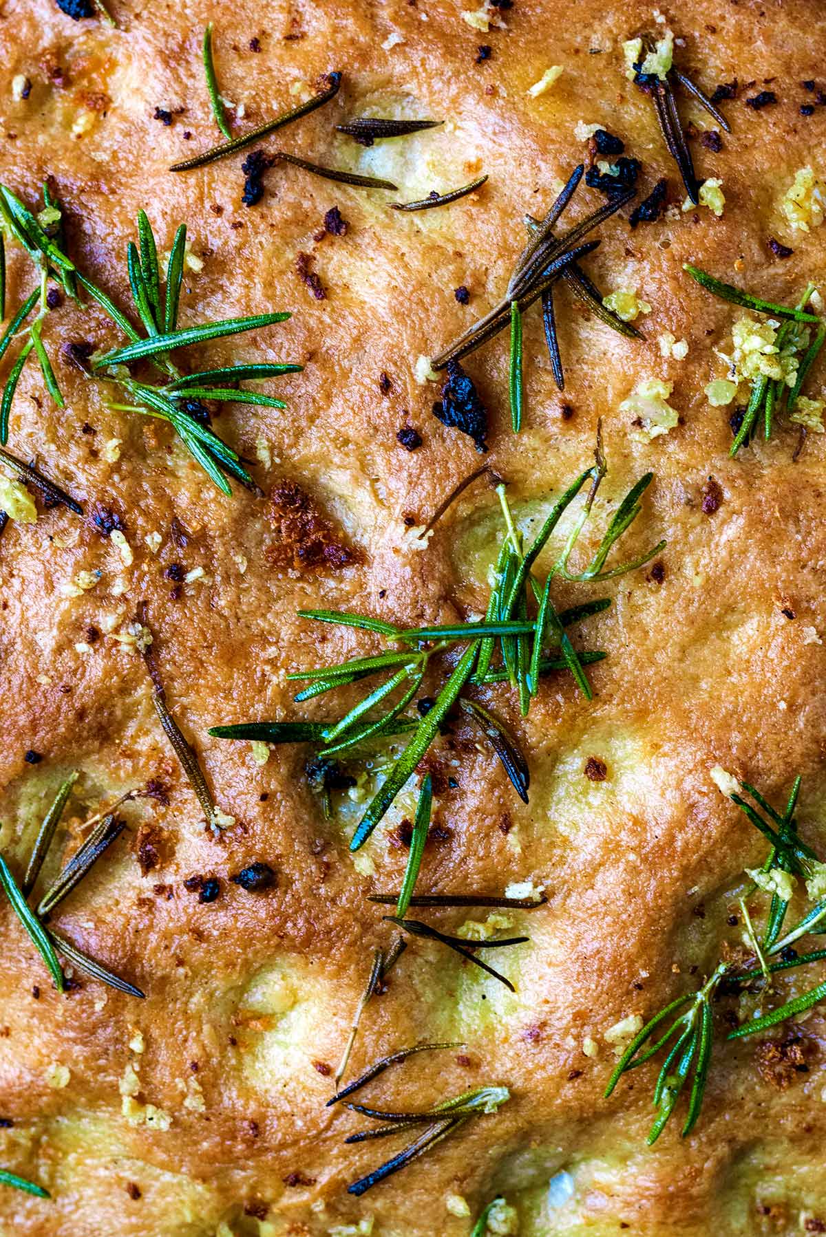 Rosemary leaves on top of cooked focaccia.