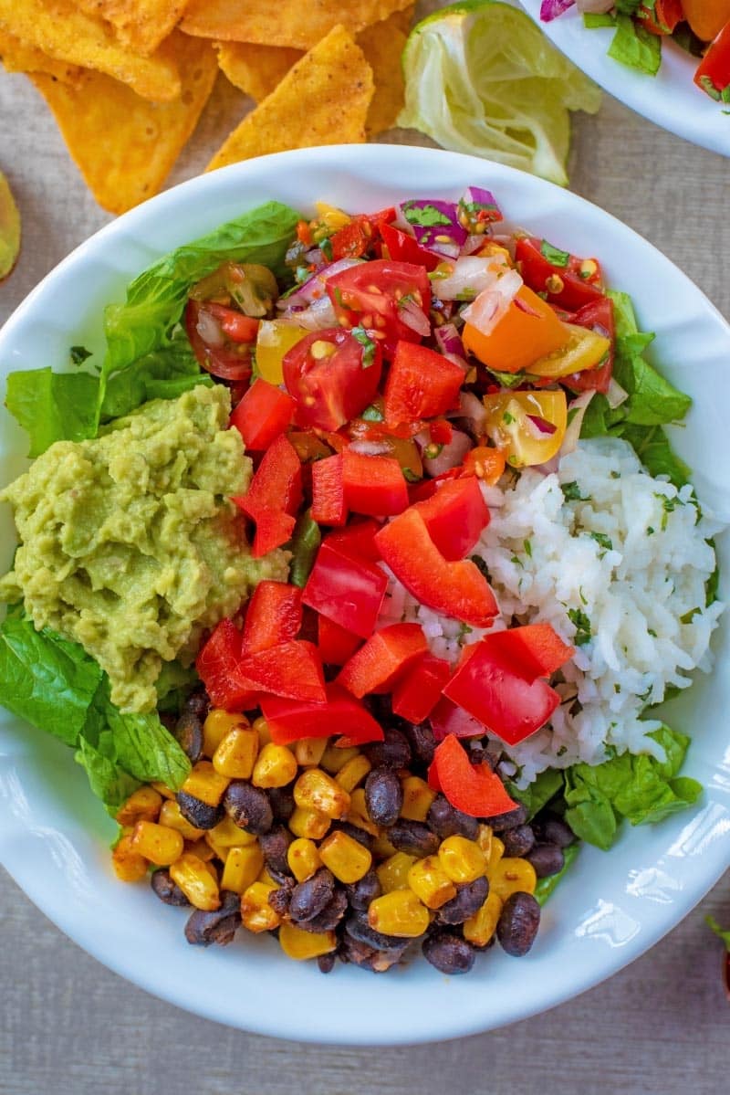 A vegan burrito bowl showing pepper, guacamole, rice and sweetcorn.