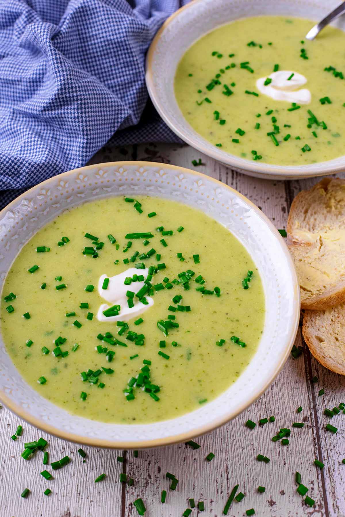 Two bowls of soup in front of a blue towel.