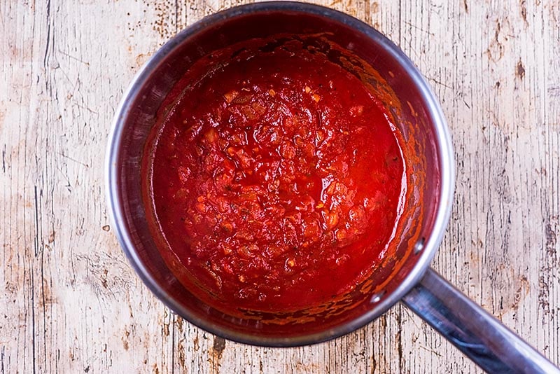 A saucepan with a cooked tomato sauce in it.