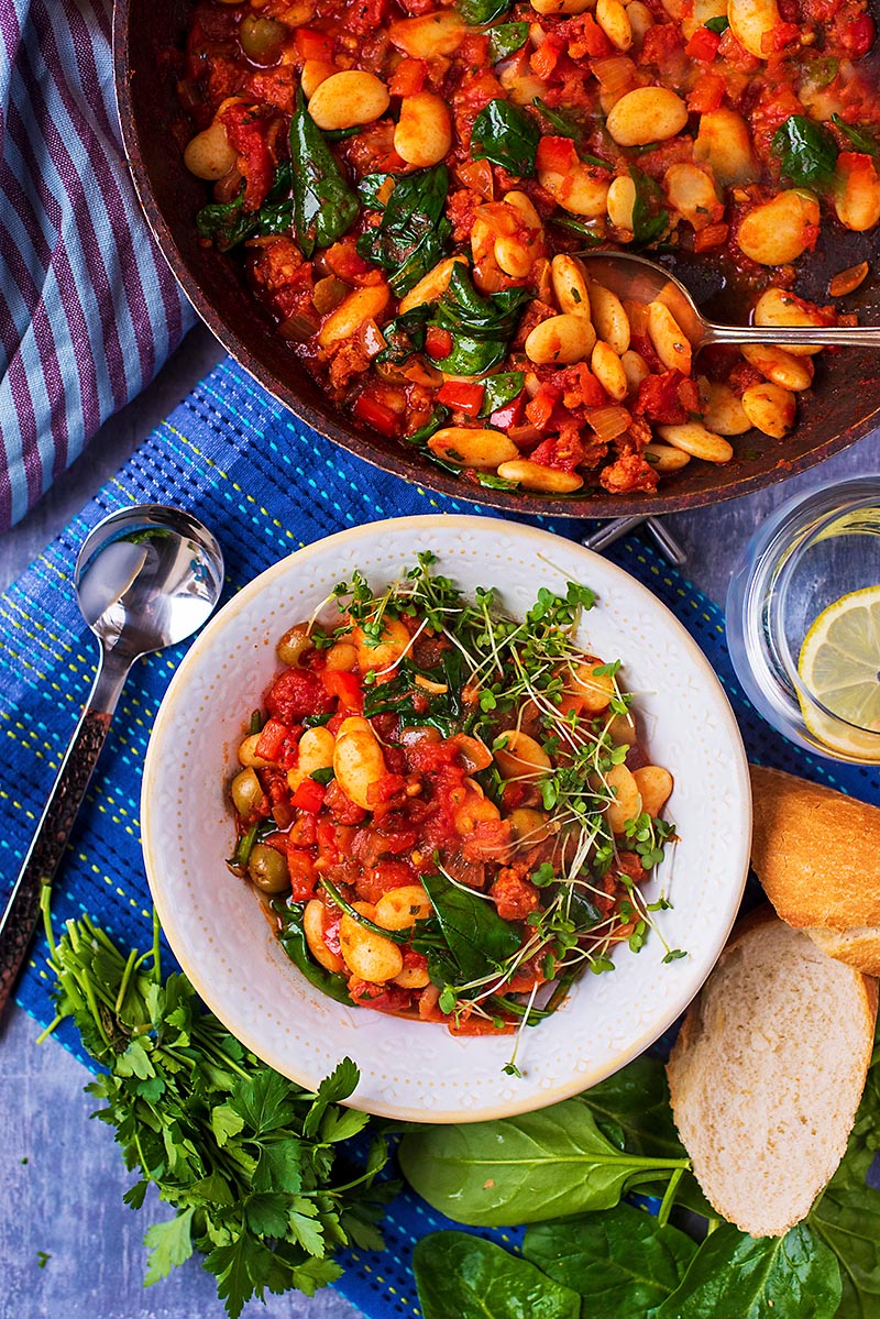 Bean Stew in a white bowl next to a pan of more stew.