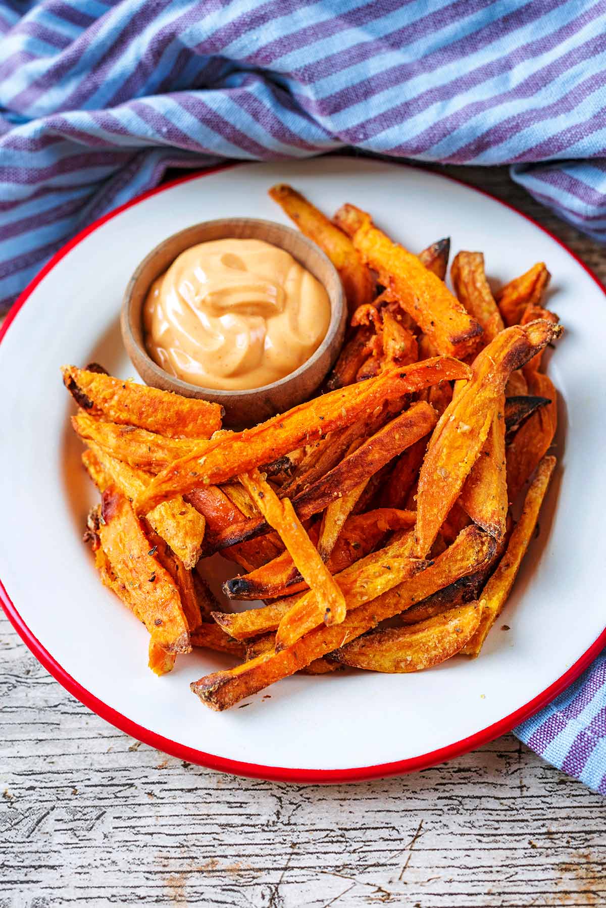 Sweet potato fries on a red and white plate.