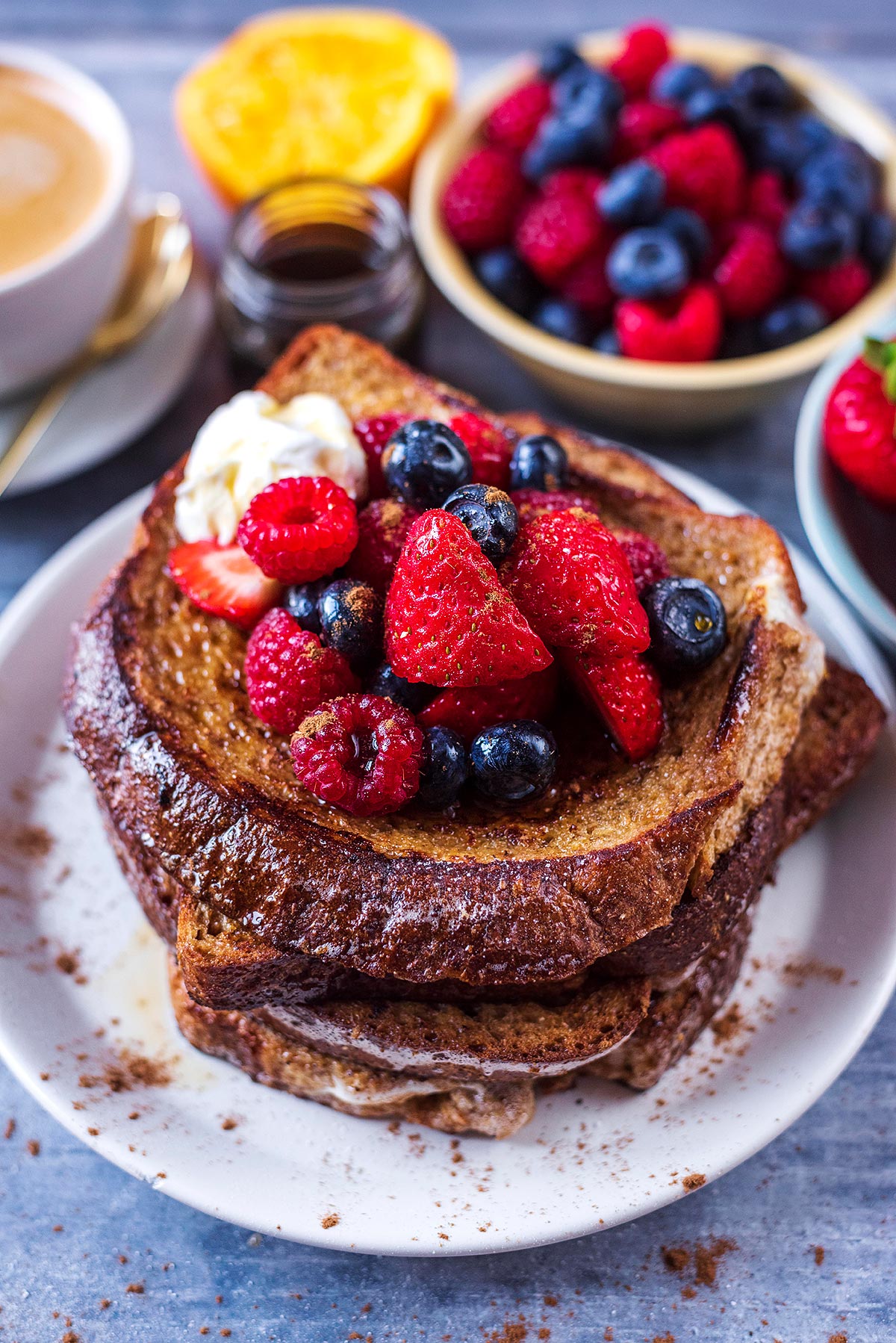 A stack of french toast topped with berries and a dollop of yogurt